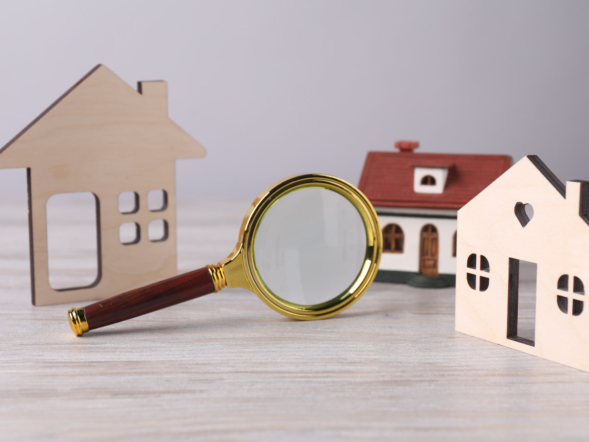 a house and a magnifying glass on a table